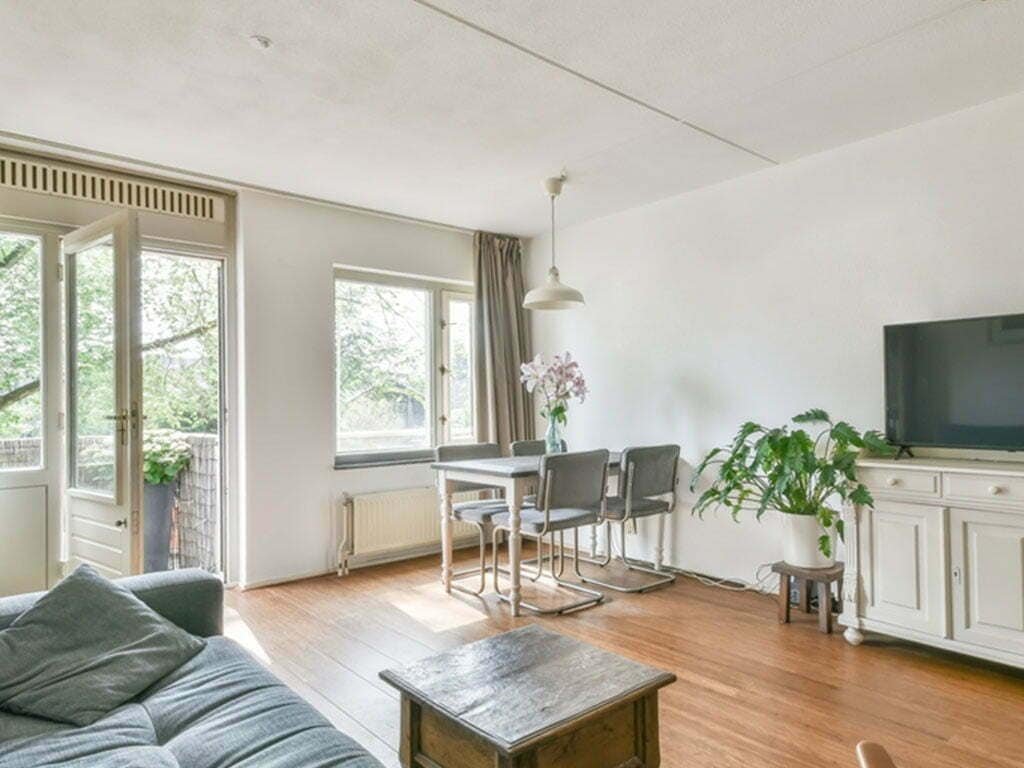 Living room with dining area, large window, and open door.