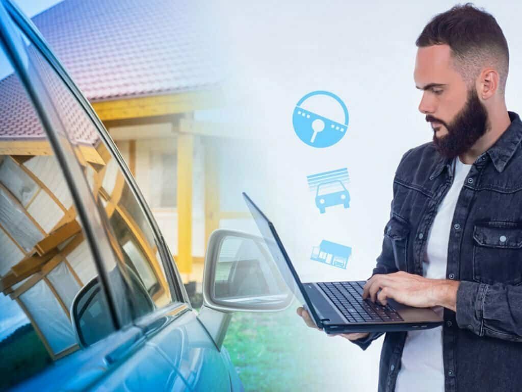 Man using laptop next to car with smart home/car icons.