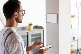 A person in a casual shirt uses a smartphone