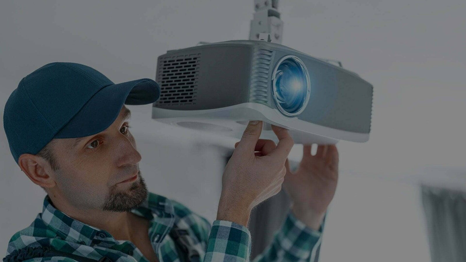 Man installing a ceiling-mounted projector.