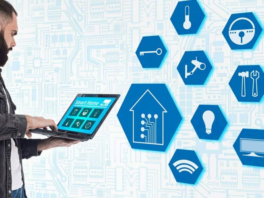 Man using laptop with smart home icons on background.