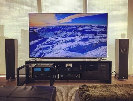 Television showing snowy landscape with two large speakers.