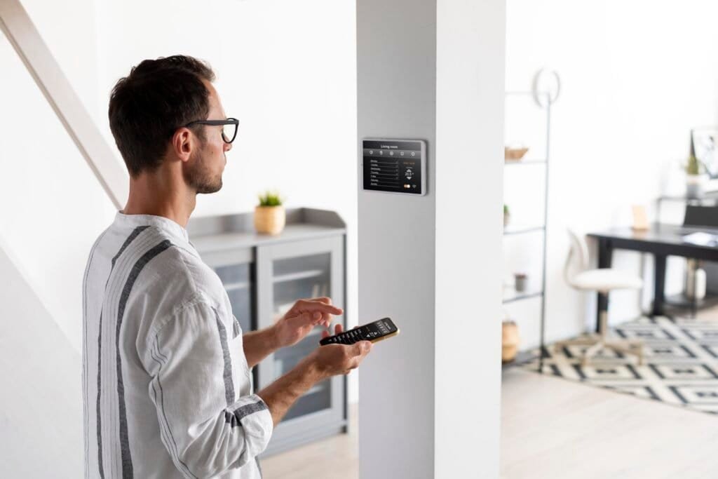 Man using phone and wall panel to control smart home.
